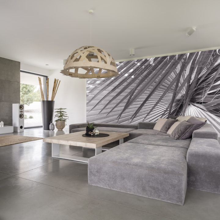 Comfy grey corner sofa with pillows in the living room with big poster