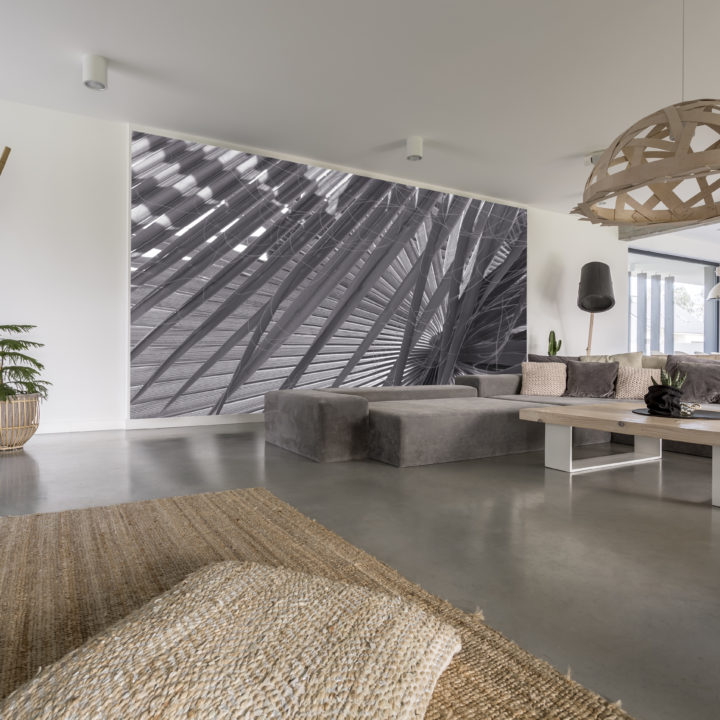 Decorative chandelier above designed table in living room with grey mural on wall