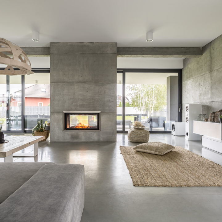 Spacious villa interior with cement wall effect, fireplace and tv
